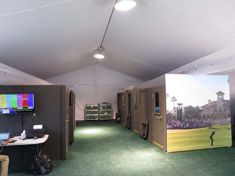Several broadcast booths set up inside a tent for international broadcast
