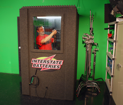 A man doing product testing for Interstate Battery inside of a WhisperRoom