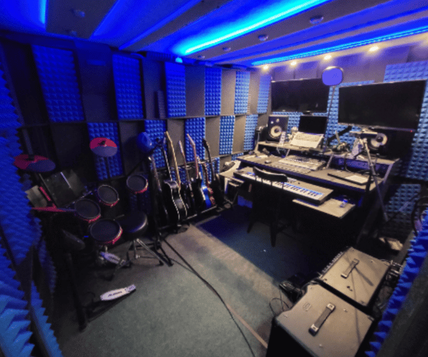 The interior of a whisperroom portable recording studio with a lot of recording gear and musical instruments inside.