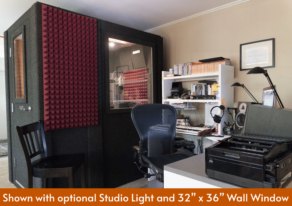 A WhisperRoom MDL 4284 S shown inside of a home recording studio next to a desk and various recording gear.