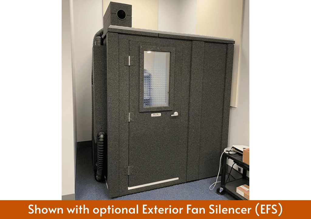 A WhisperRoom sound booth MDL 7272 shown inside of a room with the Exterior Fan Silencer placed on top of the booth.