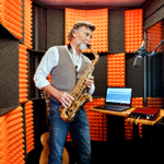 Image of a man recording saxophone inside of his WhisperRoom soundproof booth