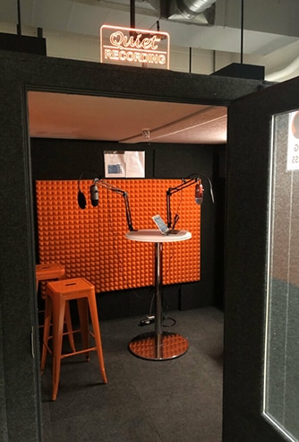 Cornell's WhisperRoom shown with door open and podcasting gear inside.