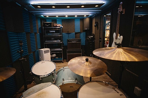 Drums, amps, and various other instruments inside of a WhisperRoom practice studio.