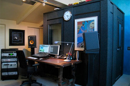 A recording booth with assorted audio gear inside of a home studio