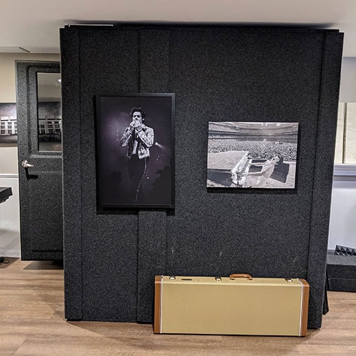 A WhisperRoom MDL 4872 S shown from the side with an open door inside of a home studio.