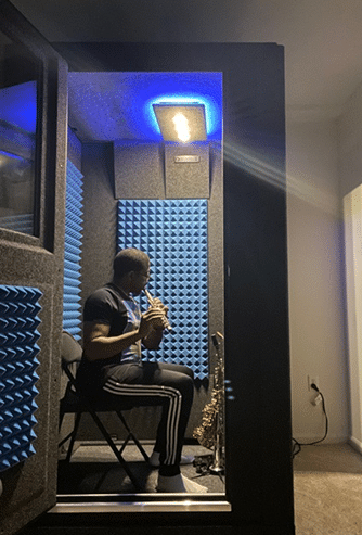 Musician Antonio Hart paying flute inside of his WhisperRoom sound isolation booth.