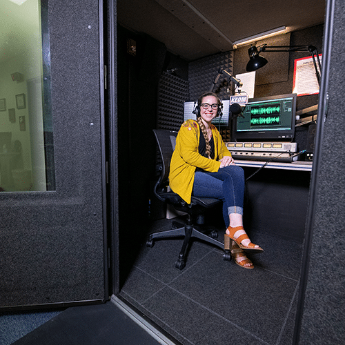 A student inside of KEOM's WhisperRoom broadcast booth.
