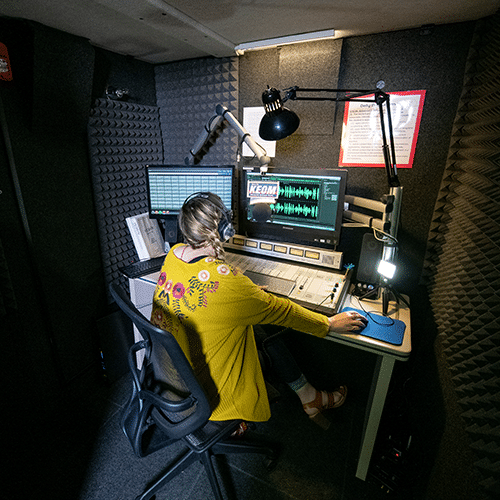 A student working on a podcast inside of KEOM's WhisperRoom broadcast booth.
