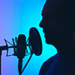 Man recording vocals into a condenser microphone