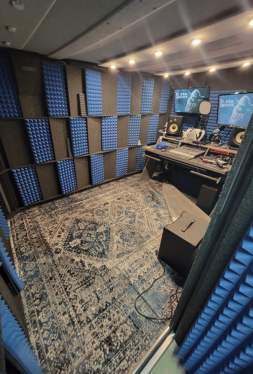 A producer's recording desk inside of a WhisperRoom MDL 96144 S sound booth.