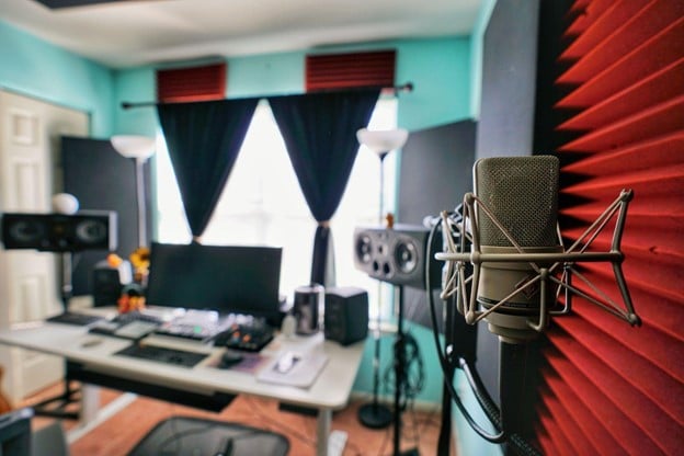 A microphone and other recording equipment set up in a home studio.