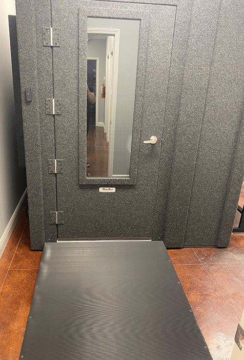 A WhisperRoom Audiology Deluxe Package is shown with the door closed inside of an audiologist's office.