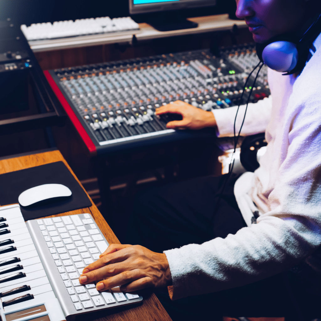 A producer mixing sound levels while working inside of a home recording studio.